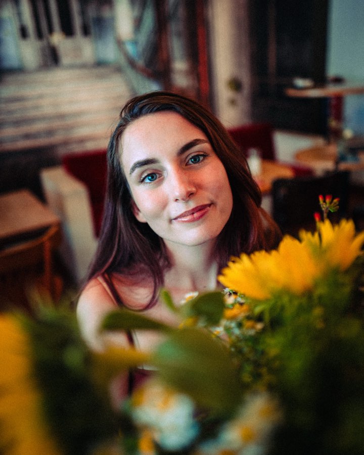 Portrait of a smiling woman behind yellow flowers