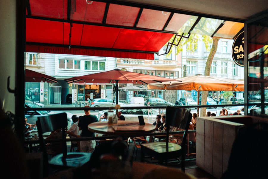 View from inside a café with red awnings onto the street