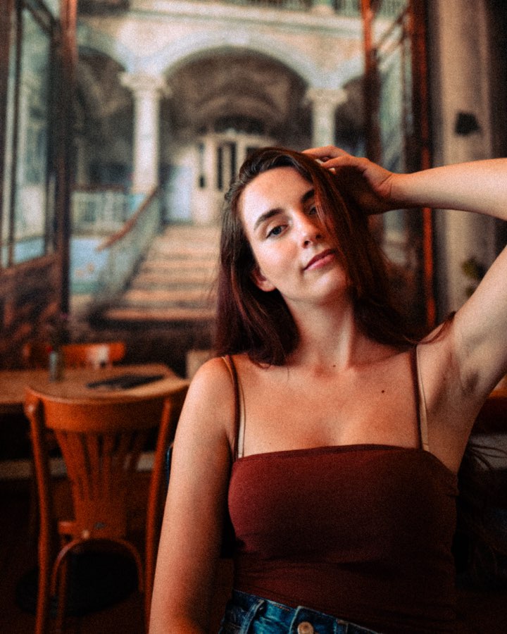 Woman with her hand in her hair sitting in a café