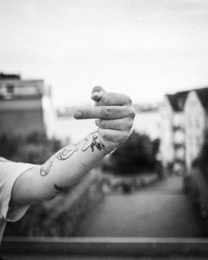 Black and white close-up of a tattooed arm and hand