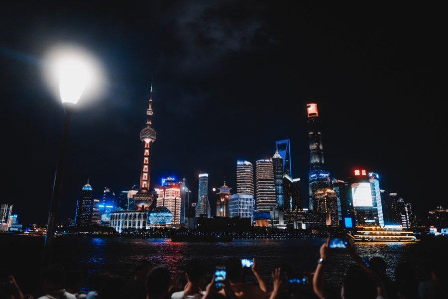 Illuminated skyscraper skyline at night with a bright full moon