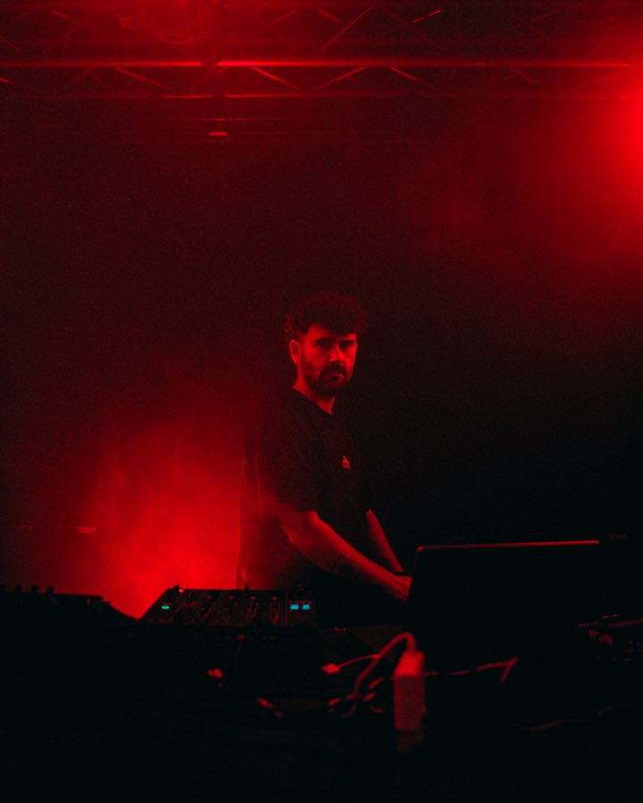 DJ at the decks bathed in red stage light