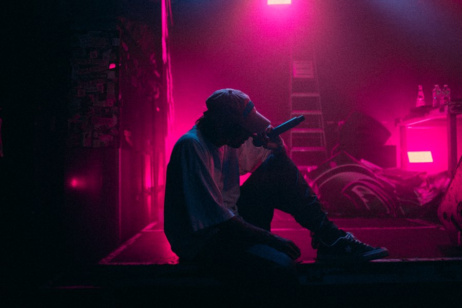 Silhouette of a person sitting on the floor in pink neon light