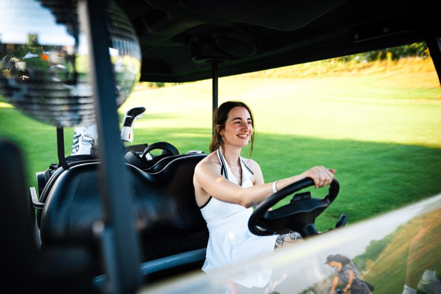 Woman driving a golf cart across the green