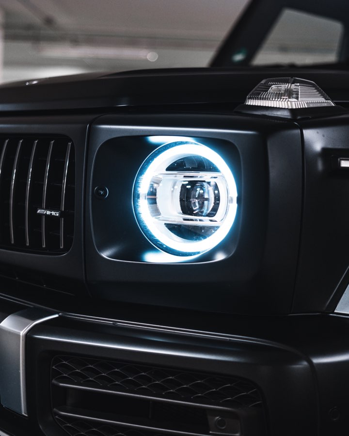 Glowing LED headlight ring of a black Mercedes G 63