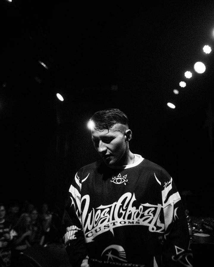 Black and white photo of Navy on stage in a Westghost jersey