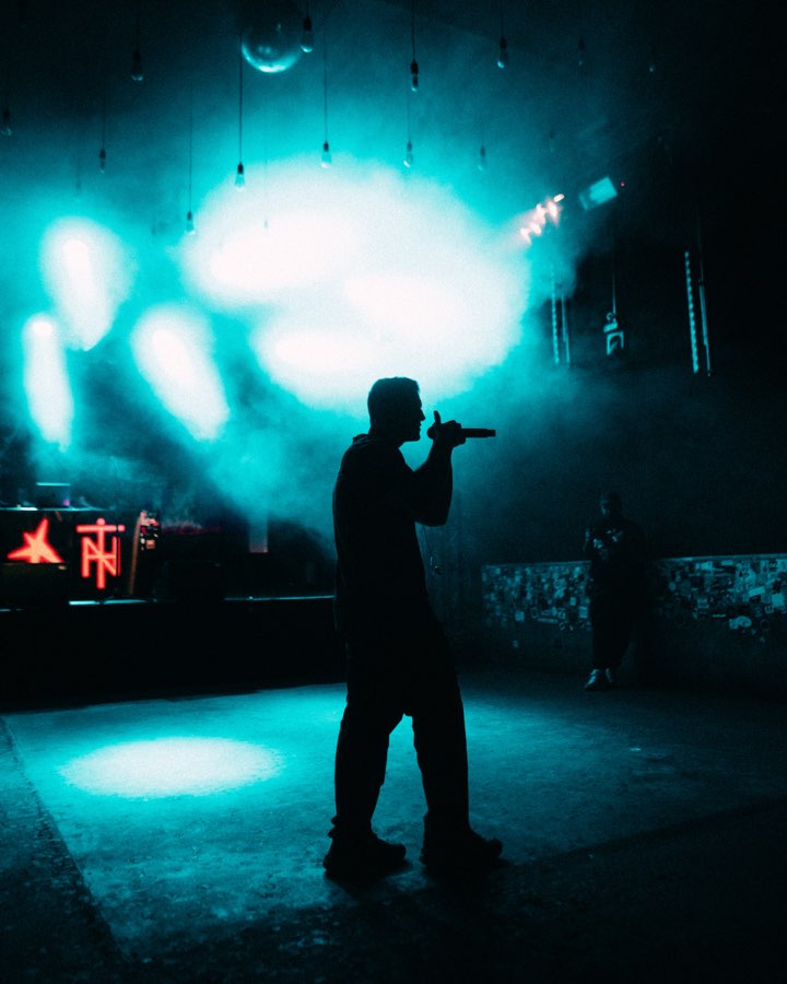 Silhouette of Navy on a stage flooded with teal light