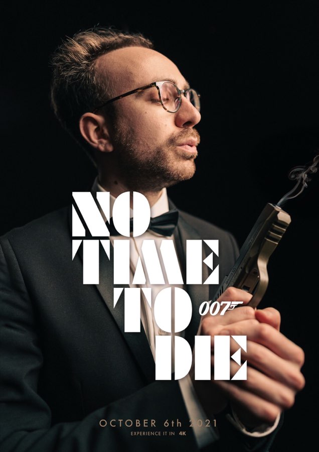 Poster of a man in glasses holding a pistol beside the No Time To Die title