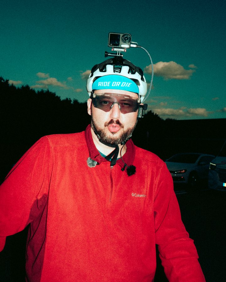 Man in a red jacket with an action camera mounted on his helmet at dusk
